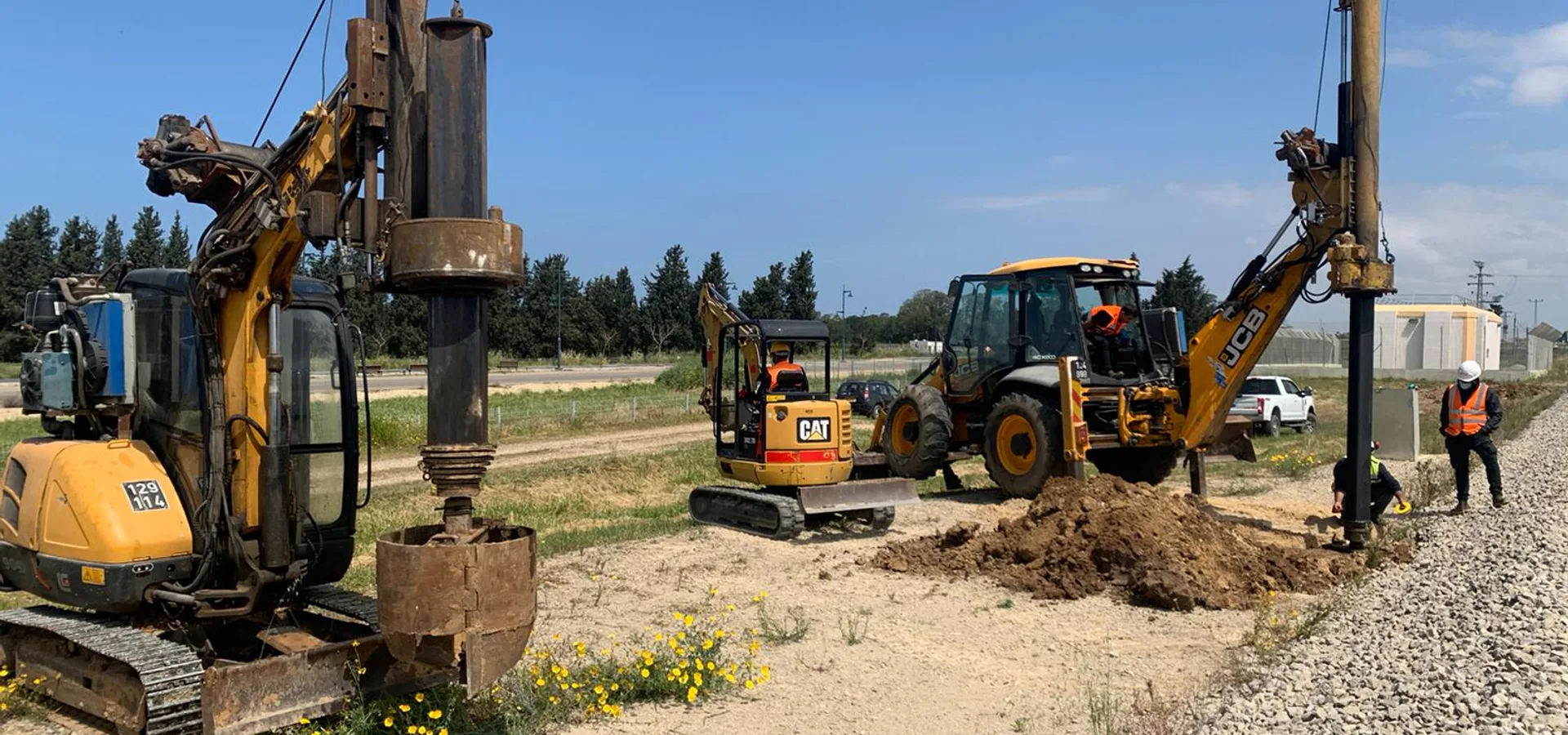 ציוד קידוח מקצועי - CAT ו-JCB באתר עבודה